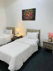 dwa łóżka w pokoju hotelowym z motocyklem na ścianie w obiekcie رافا للشقق السكنية w mieście Abha