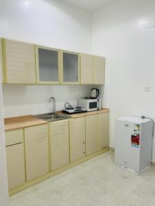 uma cozinha com armários de madeira e um frigorífico branco em رافا للشقق السكنية em Abha