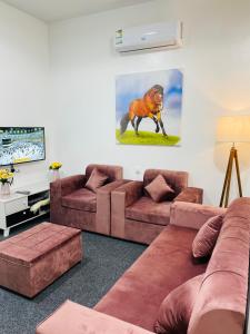 uma sala de estar com dois sofás castanhos e uma televisão em رافا للشقق السكنية em Abha