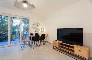 salon z telewizorem i stołem z krzesłami w obiekcie Appart 2 pièces Cannes Croisette-Martinez w Cannes