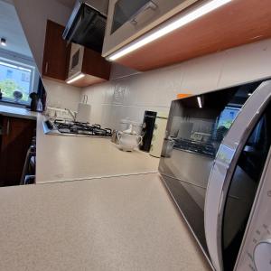 a kitchen with stainless steel appliances and a counter top at Willa 4U in Rumia +3 photos