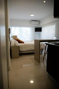 una camera con letto e scrivania con tavolo di Apart France - Con gim, piscina y estacionamiento a Río Cuarto