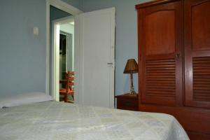 een slaapkamer met een bed en een houten kast bij Lindo apartamento com churrasqueira top in Rio de Janeiro