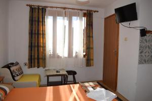 a living room with a couch and a window at Guest house Nedyalkovi in Chernomorets