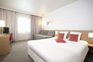 a hotel room with two beds and two lamps at Novotel Brugge Centrum in Bruges