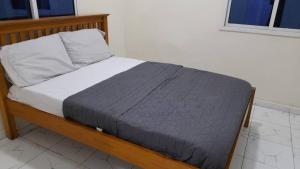 ein Bett in einem Schlafzimmer mit einem Bettrahmen aus Holz in der Unterkunft Matano Guest House in Brikama