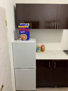 a white refrigerator with a box of snacks on top of it at Matano Guest House in Brikama