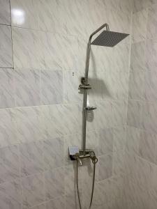 een douche met een douchekop in de badkamer bij Matano Guest House in Brikama