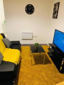 a living room with a couch and a tv at City Blessed Apartment 1 with free parking in North Shields