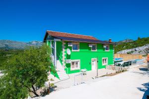 a green house on the beach at Holiday Home Mediteran in Neum