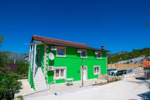 a green house with a stairs up to it at Holiday Home Mediteran in Neum
