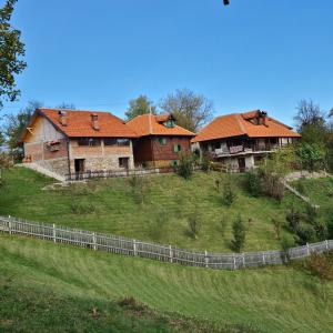 a couple of houses on a hill with a fence at Country House Sunčev breg in Bara Slatina