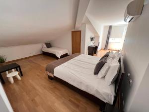 um quarto com uma cama grande e uma cadeira em Vale do Zêzere Hotel em Manteigas