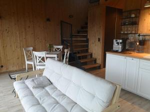un gran sofá blanco en una habitación con una mesa y escaleras en Domek u Gai, en Klecza