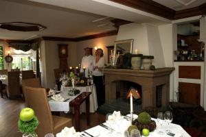 a man and woman standing in a dining room with a fireplace at Zum Sonnenwirt in Bopfingen