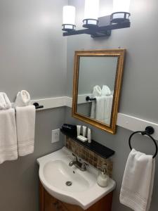 a bathroom with a sink and a mirror and towels at White Sails Inn in Kennebunk