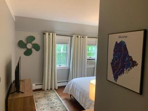 a bedroom with a bed and a tv and a window at White Sails Inn in Kennebunk