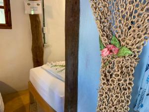 a bedroom with a bed and a curtain with a flower on it at Cabañas Ida Y Vuelta in Holbox Island