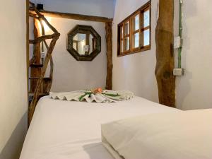 1 dormitorio con 2 camas blancas y espejo en Cabañas Ida Y Vuelta, en Isla Holbox