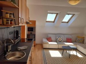 a kitchen and living room with a couch and a table at apartman Happy in Stará Lesná