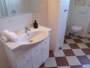 a white bathroom with a sink and a toilet at apartman Happy in Stará Lesná +4 photos
