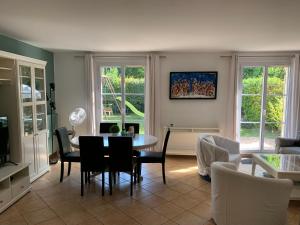 a living room with a table and chairs at DISNEY & PARIS Happy Villa for 10 persons with Private Garden & Terrace 4 bedrooms, 3 bathrooms FIBER Wifi Netflix & free Parking in Bailly-Romainvilliers