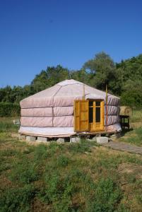 a yurt with a wooden door in a field at Yurta Flora in Torino di Sangro
