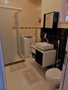 uma casa de banho com um WC, um lavatório e um espelho. em Mommy's Apartment in Copacabana no Rio de Janeiro
