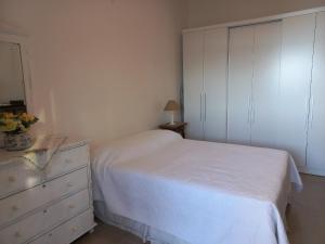 um quarto com uma cama branca e uma cómoda em Mommy's Apartment in Copacabana no Rio de Janeiro