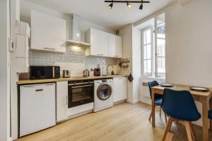 a kitchen with a washer and dryer and a table at Nice and modern flat at the heart of Panier in Marseille - Welkeys in Marseille