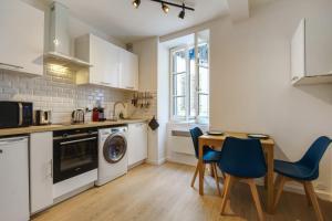 a kitchen with a table and a washing machine at Nice and modern flat at the heart of Panier in Marseille - Welkeys in Marseille