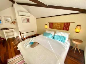 a bedroom with a large white bed with blue pillows at Cumelen in Jericoacoara