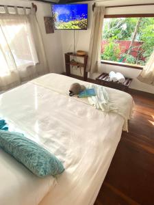 a large white bed in a bedroom with two windows at Cumelen in Jericoacoara