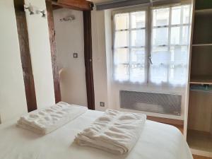 sypialnia z 2 ręcznikami na łóżku z oknem w obiekcie EXIGEHOME-Studio Cosy à 2 pas du Chateau de Versailles w Wersalu