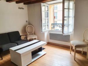 salon z kanapą i stołem w obiekcie EXIGEHOME-Studio Cosy à 2 pas du Chateau de Versailles w Wersalu