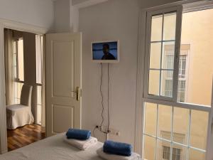 マラガにあるCozy Dorine Malaga centroのベッド1台と壁掛けテレビが備わる客室です。