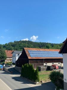 un granero con un grupo de paneles solares. en Wellness am Wald Wellness Behandlungen & Frühstück Auszeit im Odenwald en Mörlenbach