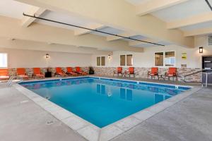 a pool in a hotel with orange chairs and tables at Best Western Blackfoot Inn in Blackfoot