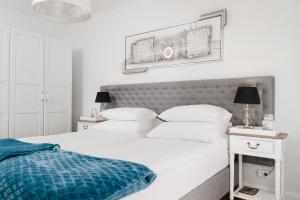 a white bedroom with two beds and two lamps at Apartament Marta Luxury in Krynica Morska