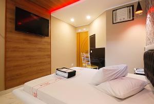 a hotel room with a bed and a tv on the wall at Red Rose Motel & hotel in Franco da Rocha