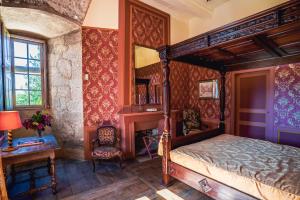 a bedroom with a canopy bed and a desk at Château de La Vigne in Ally