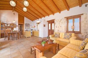 a living room with a couch and a table at Villa Athina Fiskardo by Villa Plus in Tzamarelláta