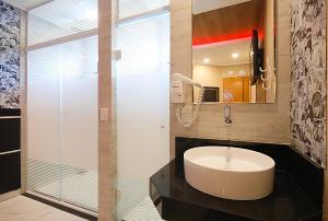 a bathroom with a sink and a glass shower at Red Rose Motel & hotel in Franco da Rocha