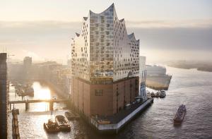 a large building on the water with a cruise ship at Hotel Hamburg Inn Free Parking in Hamburg