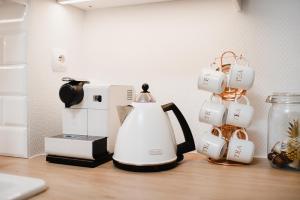 a coffee maker and cups on a table at Apartament Marta Luxury in Krynica Morska