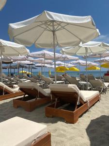 a group of lounge chairs and umbrellas on a beach at Royal Palace in Olympic Beach