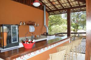 a kitchen with a bar with chairs and a patio at Artesanal Gourmet e Pousada in Posse