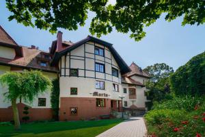 a large white building with a tree in front of it at Apartament Marta Luxury in Krynica Morska