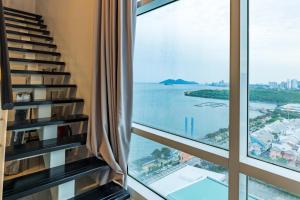 a view of the ocean from a hotel room window at Maritime Luxury Duplex 2Bedrooms 6-10pax in Jelutong