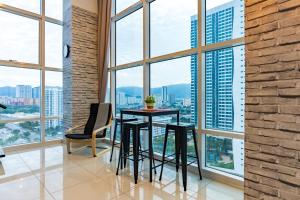 a table and chairs in a room with large windows at Maritime Luxury Duplex 2Bedrooms 6-10pax in Jelutong +5 photos
